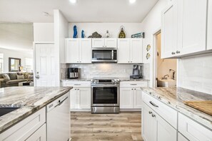 Stainless steel appliances and coastal countertops and backsplash!