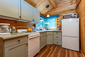 The Kitchen with stove, refrigerator, microwave, coffee maker, and all utensils.