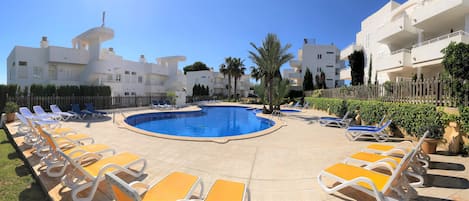 Residential El Puerto I community swimming pool with a large solarium area.