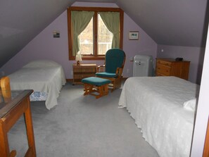 Twin bedded room with desk, easy chair, dresser, AC, WIFI and private bathroom.