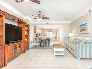 The open floor plan living area with a flat screen TV and sleeper sofa