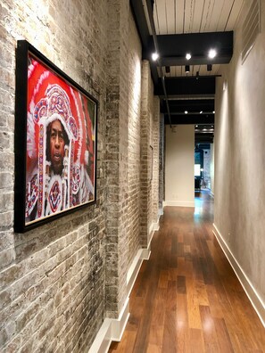 Long brick lined hallway with half bath near living room at end. 
