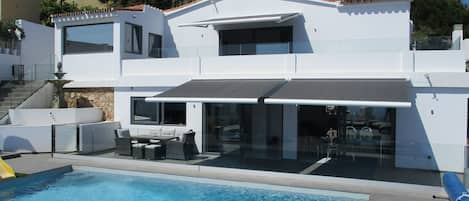 Pool with glass balustrade all around and villa 