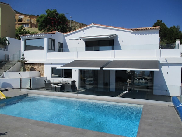 Pool with glass balustrade all around and villa 