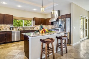 Premium appliances, granite counters, and garden views make cooking here a tropical delight.