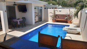 Pool area with fountain and coral stone deck, Smart TV and table