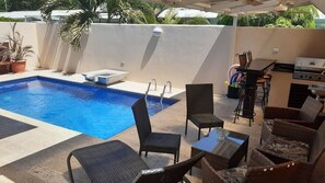 Pool area with seating and gas BBQ grill