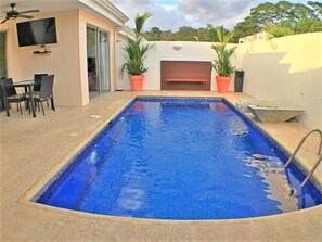 Pool area with fountain and coral stone deck, Smart TV and table