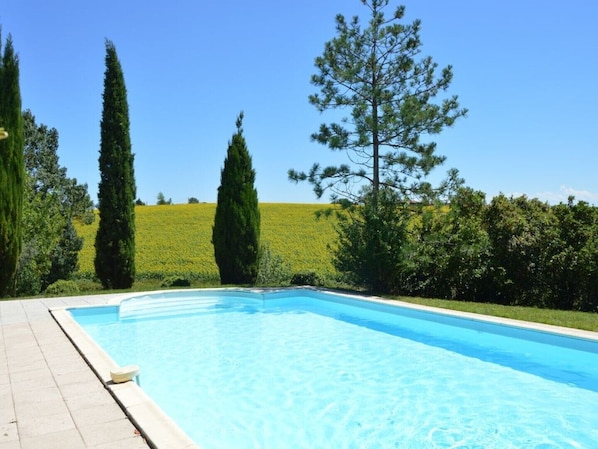 Piscine et son solarium vue sur les champs de tournesols et sur les Pyrénées 