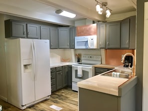 Kitchen with full sized fridge, stove, microwave and dishwasher