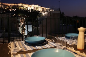 Dining on the roof top at night with a view of the Acropolis
