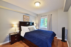 Queen size bed in bedroom with black out curtains. 