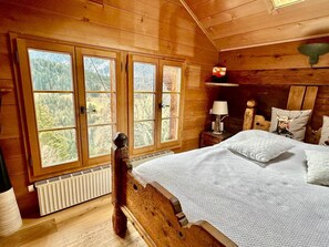 The bedroom features a queen-sized bed and offers stunning views of the mountains.