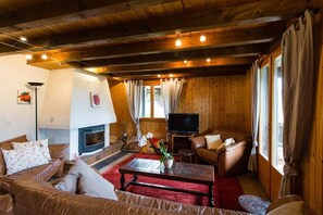 the cozy living room with tv and a warm fire place 
