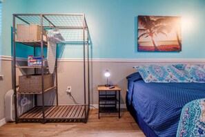  room with queen size bed, bedside table with lamp, fan, closet, clothes hangers