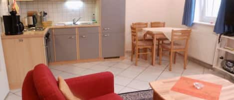 Wohnzimmer mit Küchenzeile, Sitzgruppe und Essplatz