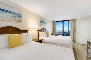 Bask in sunlit double delight as the sunlight pours into the room, highlighting the inviting allure of two beds against the stunning ocean backdrop, creating a bright and airy ambiance.