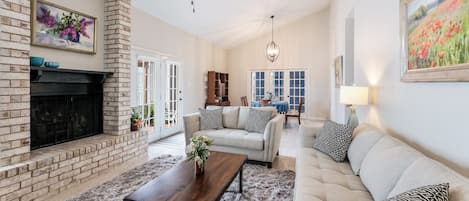 Very airy living and dining area with views through french doors to back patio.