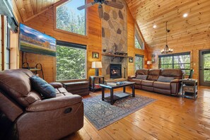Spacious living room with gas fireplace, TV, & comfy seating.