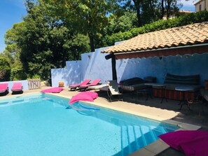 Pool side with shady awning  and lots of pool-side furniture