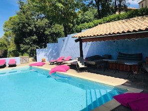 Pool side with shady awning  and lots of pool-side furniture