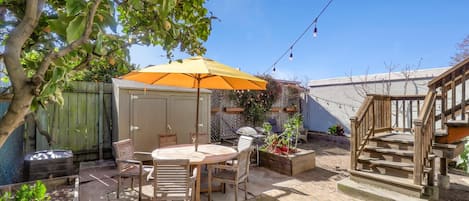 Sunny backyard with seating,  grill, vegetable garden