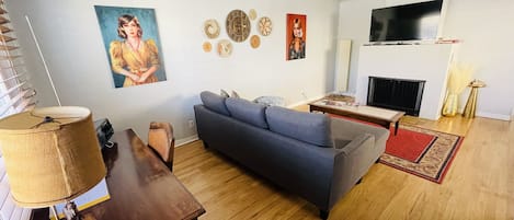 Living room with a couch that fold outs to queen bed.