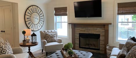 Stunning living room features wood burning fireplace, vaulted ceiling, smart tv