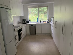 Microwave, stove top, oven, dishwasher, fridge, crockery and utensils. 