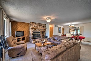 The living room features a stone fireplace and plush furniture.