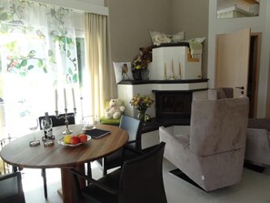 Wohnzimmer mit Esstisch und Kachelofen