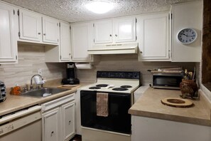 Kitchen with microwave, oven, dishwasher, and fridge.
