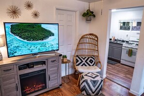 Small living room leads directly into the kitchen.  Cozy up in our egg chair by the "fire"! Read a book or watch TV in our comfy living room area. 