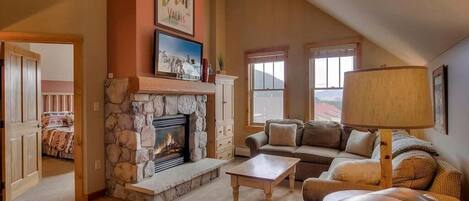 Very cozy living room with vaulted ceilings and gas fireplace.