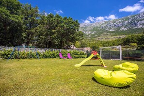 Kid's playground with swing and slide and football field.