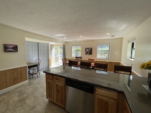 View from the kitchen of the dining area and sliding doors to the deck. 