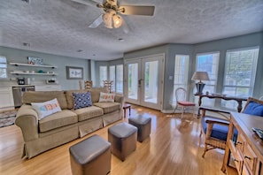 Bright, open living area with cozy seating and natural light perfect for unwinding after beach days