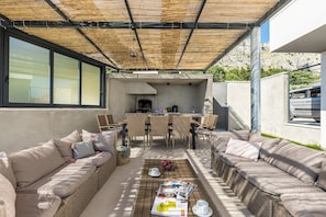 Summer kitchen, outdoor dining area, and lounge in the shadow