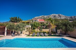 Swimming pool depth goes from 1m to 1.5m with 8 deck chairs.