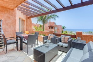 Large terrace with chill out area and dining table with seaview.