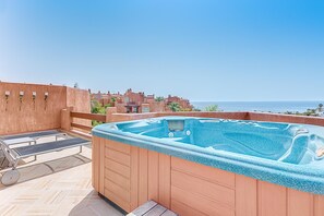 Jacuzzi auf dem Dach mit Sonnenliegen