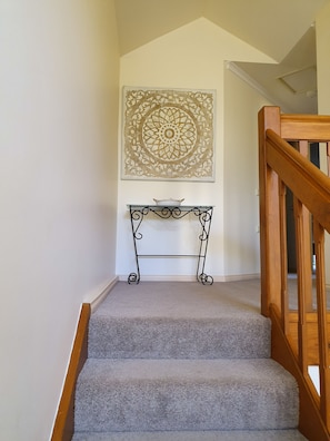 Staircase leading to upstairs bedrooms and bathroom