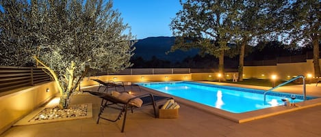 Pool area by night with great lights and view on the mountains