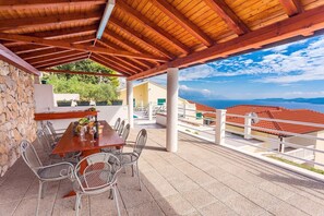 Pool and covered outdoor dining area with wooden playhouse next to it