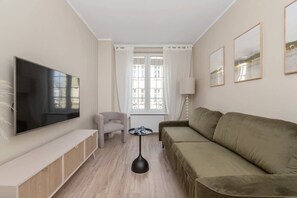 The cozy living room featuring a comfy sofa perfect for relaxing after a day of exploring the city.