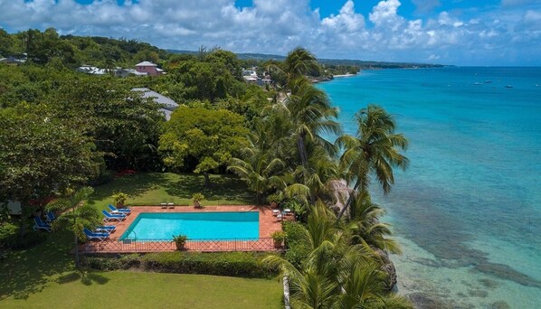Birds eye view of the villa's pool and front garden - the beach is a minute stroll from the villa