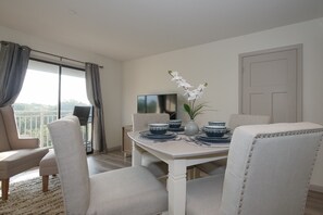 Carolina Beach Club 429 - Dining Area - Dining and living room area with glass sliding door to balcony offers side view of the amazing Atlantic ocean .