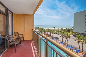A comfortable balcony space with a delightful poolside and ocean view perspective.