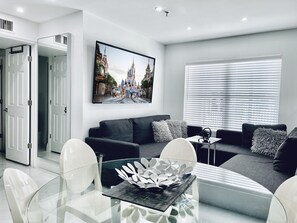 Dining & Living room with sofa group and 70 inch Smart TV. One sofa can be single bed.