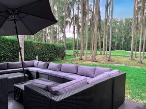 Back garden with outdoor living room style patio area overlooking lake and Saddlebrook Golf Resort Course.